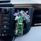 a glass jar with a variety of beaded flowers in a car