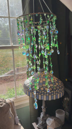 video of a suncatcher with green beads shimmering in the sunlight
