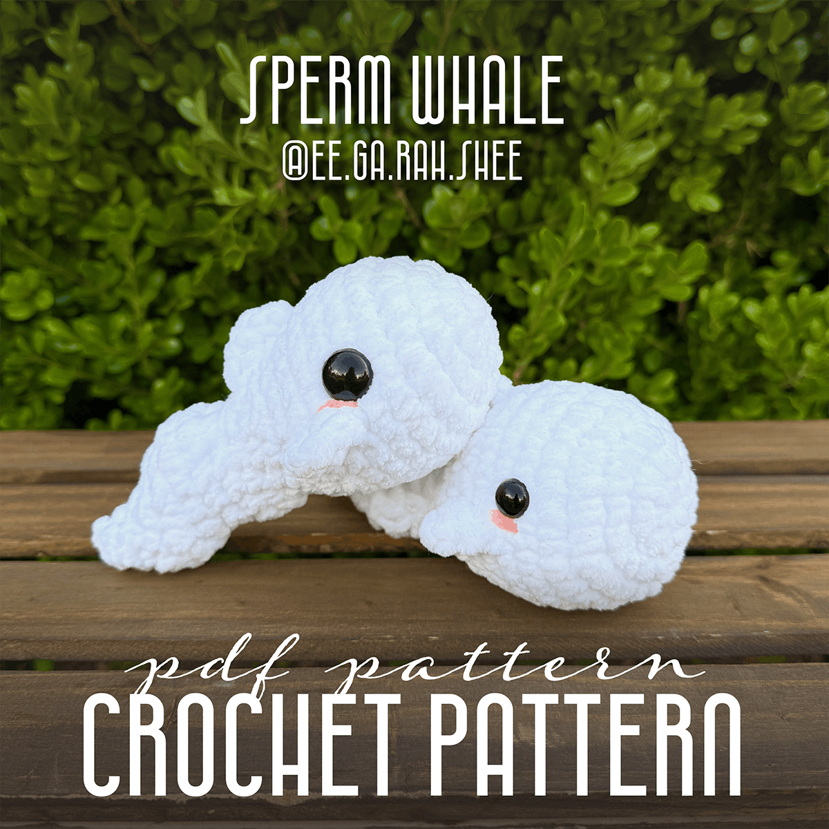 Crocheted sperm whale toy with text overlay on a wooden surface and green foliage background