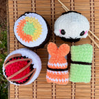 Crocheted sushi toys on a bamboo mat